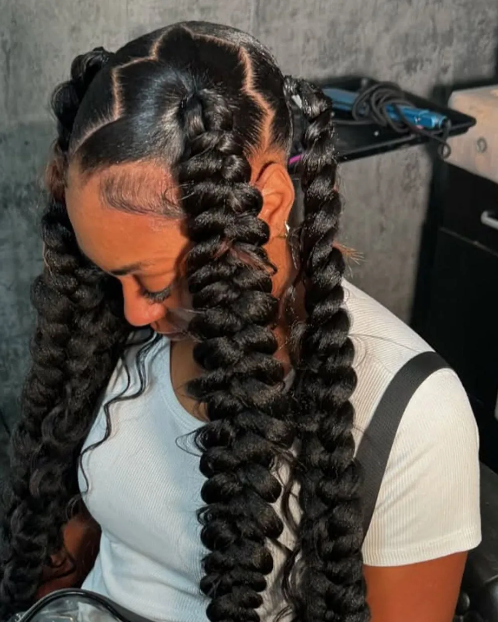 Two jumbo braided ponytails with curly ends